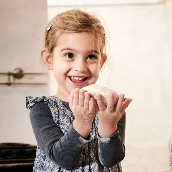 The girl is kneading dough in the kitchen at Museum Give